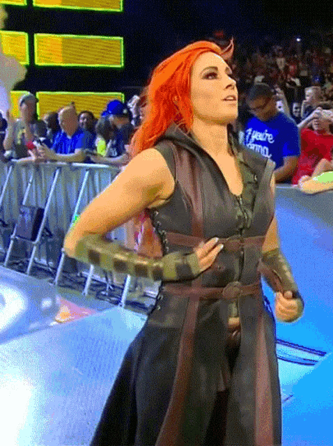 a woman with red hair is standing in front of a crowd wearing a shirt that says ' i 'm yours '