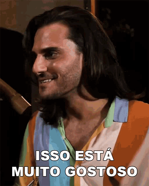 a man with long hair is smiling with the words isso esta muito gostoso above him