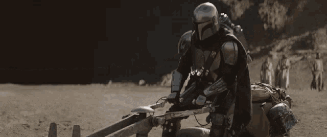 a man in a helmet is sitting on a motorcycle in the desert .