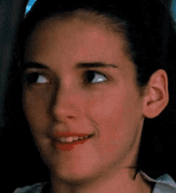 a close up of a woman 's face with a pixelated red heart in the corner