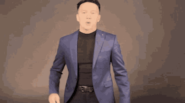 a man in a blue jacket is dancing with his arms outstretched