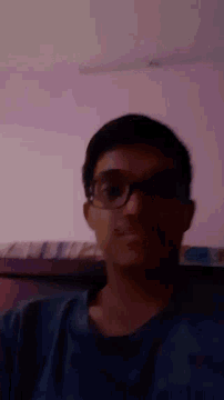 a man wearing glasses is laying on a bed