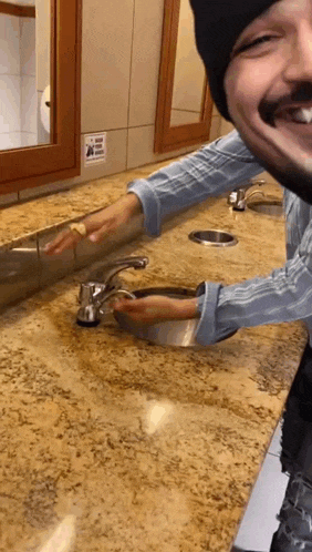 a man is washing his hands in a public restroom