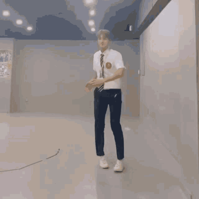 a man in a white shirt and tie is dancing with his hands in the air