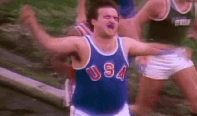 a man wearing a usa jersey is standing in front of a crowd .