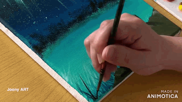 a person is painting on a canvas with the words made in animatica on the bottom right