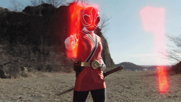 a person in a red superhero costume is holding a sword