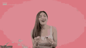 a woman is smiling while holding a fork in front of a pink background that says imgflip.com on it