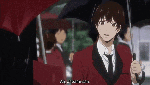a young man in a red suit and tie is holding an umbrella .