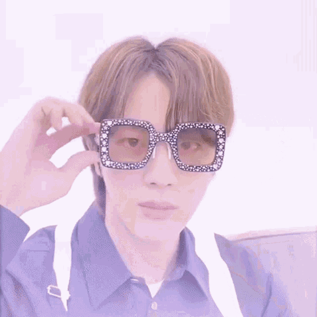 a close up of a person wearing sunglasses with rhinestones .