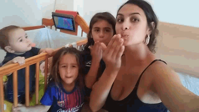 a woman is taking a selfie with two children and one of the children is wearing a shirt that says coca cola