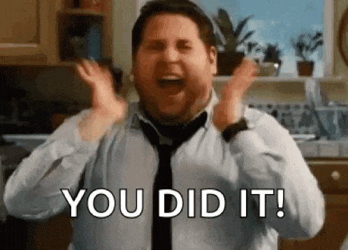 a man in a tie is screaming with his hands in the air .