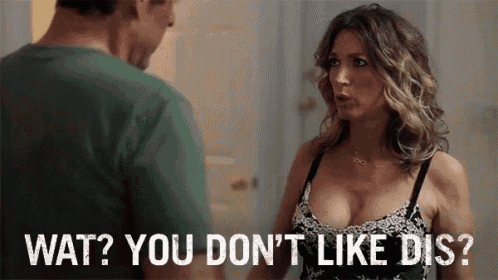 a woman in a bra is talking to a man with the words wat ? you don 't like dis ? below her