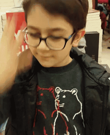 a young boy wearing glasses and a black shirt with a hamster on it