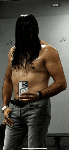 a shirtless man is taking a picture of himself in a dressing room