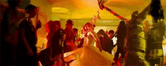 a bride and groom are dancing at a wedding reception in a room filled with people .