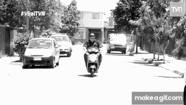 a black and white photo of a man riding a motorcycle with the hashtag viraltvn