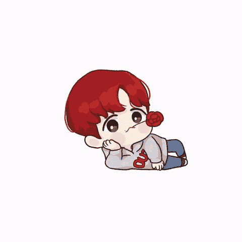 a boy with red hair is laying down with a red rose in his mouth