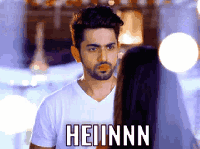 a man in a white t-shirt with the word heiinnn on the front