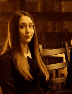 a woman with long hair is sitting in a chair .