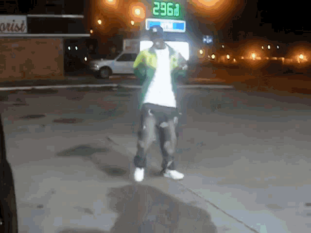 a man is dancing in front of a gas station sign that says 2967