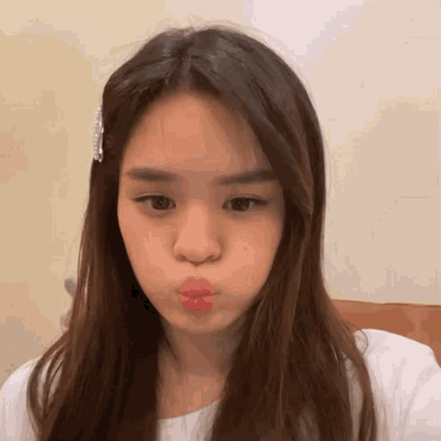 a woman with long brown hair is making a funny face