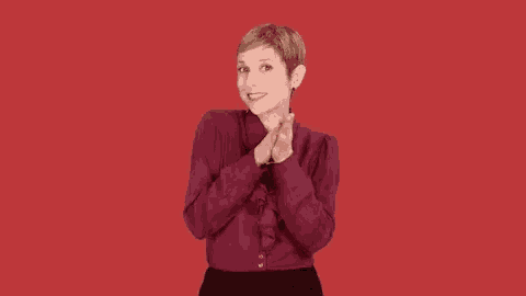 a woman in a burgundy shirt and black skirt is making a funny face