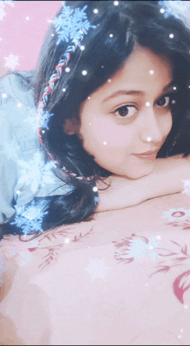 a girl with snowflakes in her hair is laying down on a bed