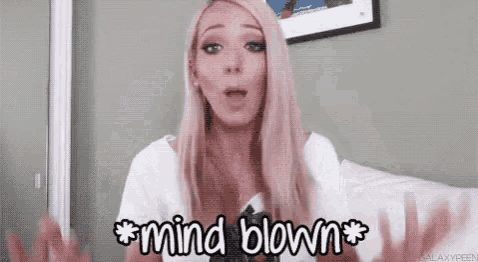 a woman is making a funny face and saying `` mind blown '' while sitting on a bed .