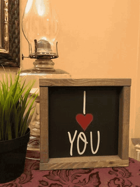 a framed sign that says i love you with a red heart
