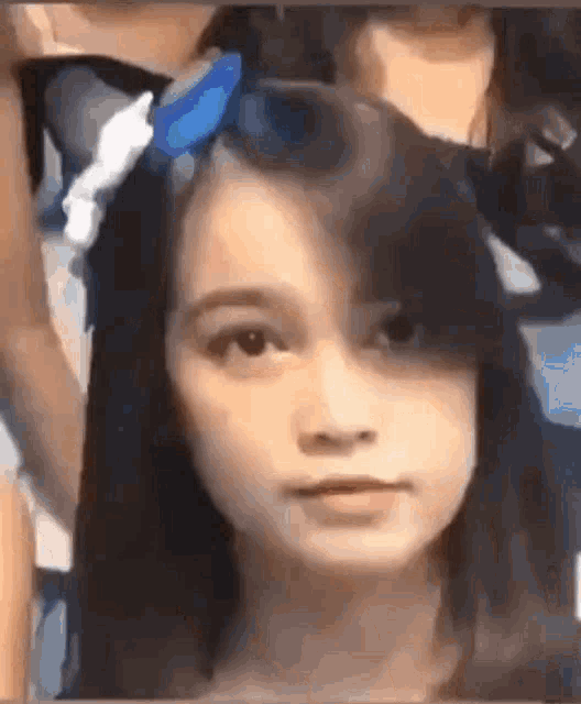 a close up of a young girl 's face with a bow in her hair .