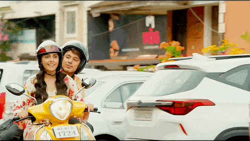 a man and woman riding a yellow scooter with a license plate that says 1724
