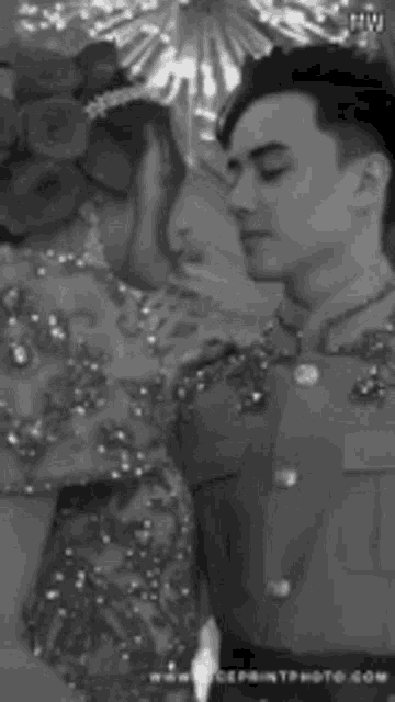 a black and white photo of a man and woman kissing