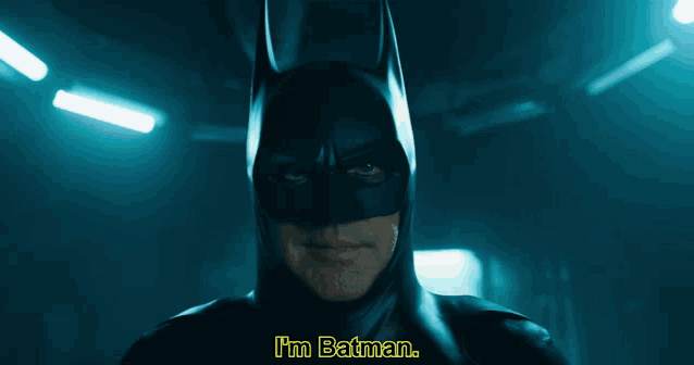 a man in a batman costume says " i 'm batman " in yellow letters