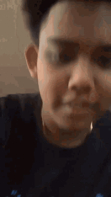 a close up of a person 's face in a black shirt .