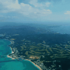 an aerial view of a golf course surrounded by turquoise waters