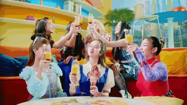 a group of women are sitting around a table holding drinks .