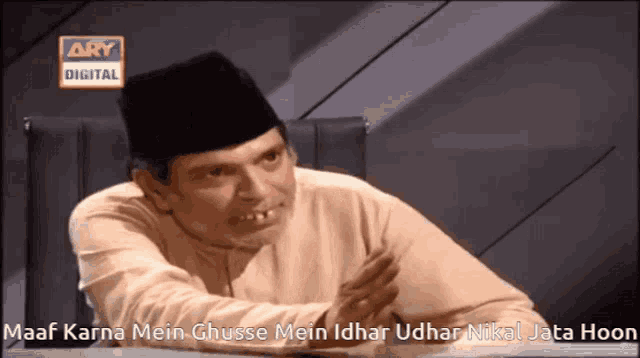 a man sitting at a table with a caption that says maaf karna