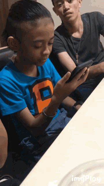 a boy in a blue shirt with the letter p on it