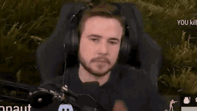 a man wearing headphones is giving a thumbs up sign .