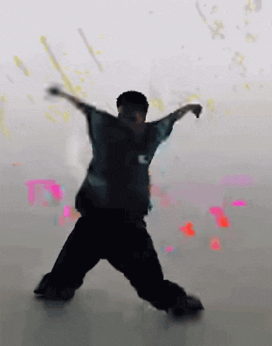 a man is dancing with his arms outstretched and a shirt that says kc on it