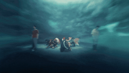 a group of people are standing in a dark room