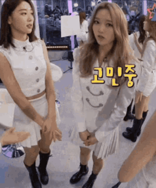 a group of girls are standing next to each other with korean writing on the wall