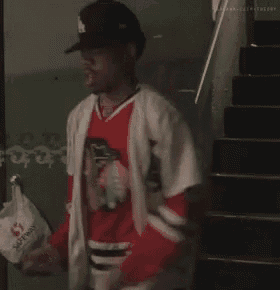 a man in a baseball uniform is holding a bag that says safeway on it .