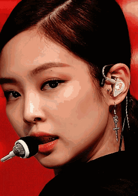 a close up of a woman 's face wearing a microphone and earrings