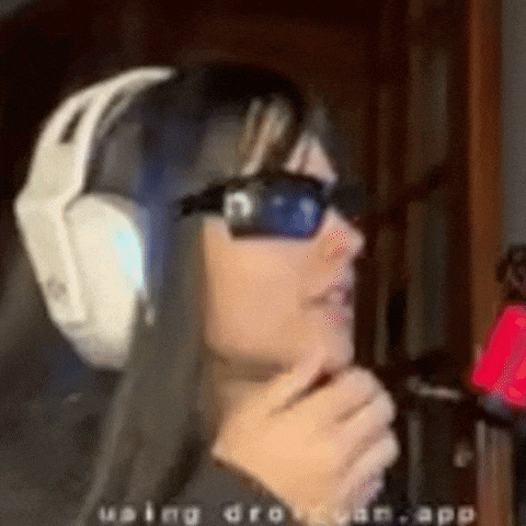 a woman wearing headphones and sunglasses is standing in a room .