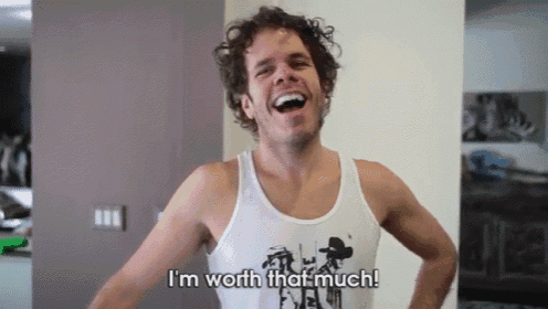 a man in a tank top is laughing and says i 'm worth that much