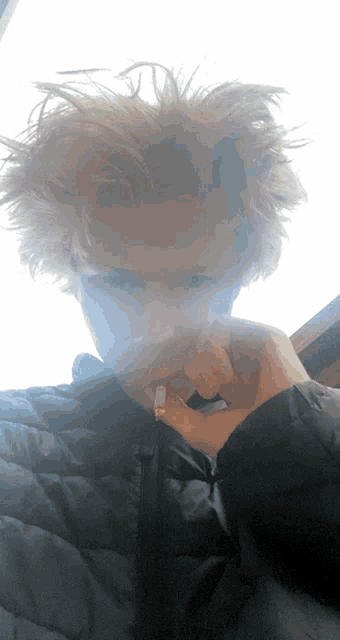 a person with messy hair smoking a cigarette in front of a window