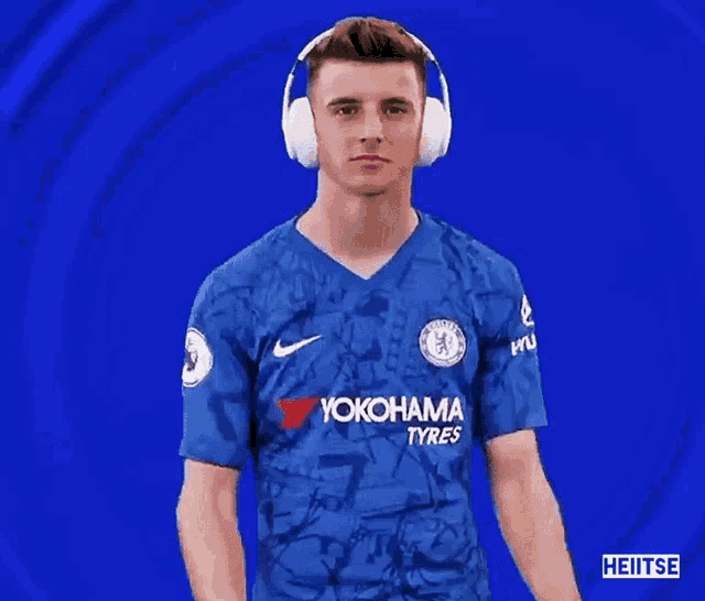 a man wearing headphones and a blue yokohama jersey
