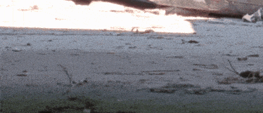 a blurred image of a concrete surface with a few pieces of grass